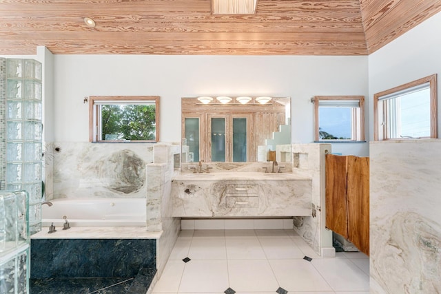 bathroom with vanity, tiled tub, and tile patterned floors