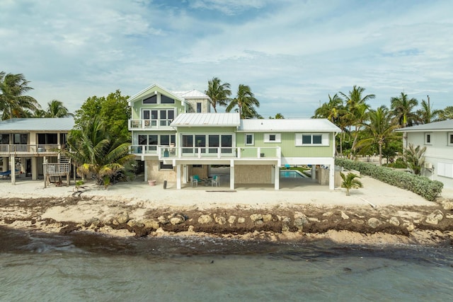 rear view of property with a patio, a water view, and a balcony