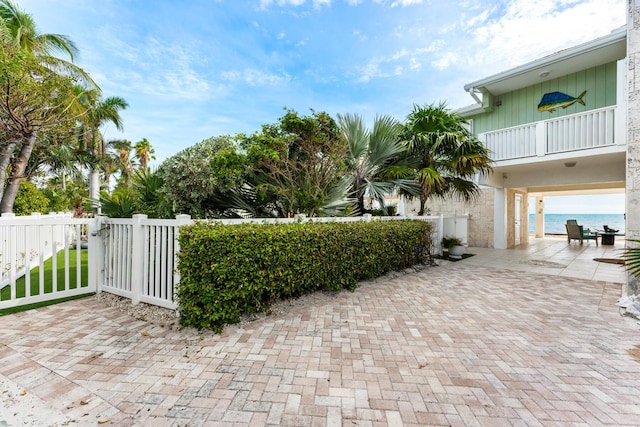 view of patio featuring a water view and a balcony