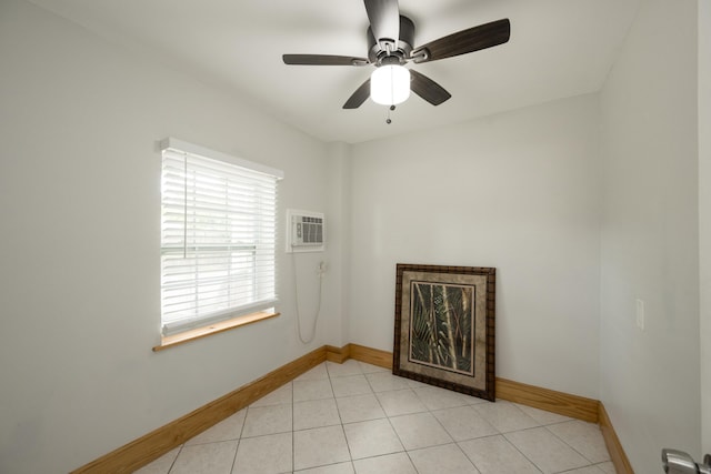 tiled spare room featuring ceiling fan and a wall mounted air conditioner