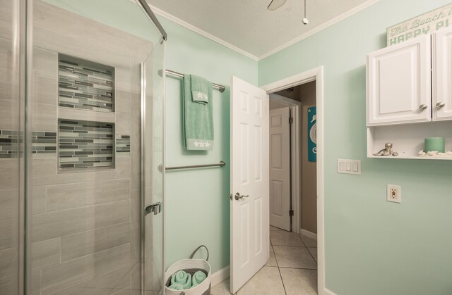 bathroom featuring ceiling fan, ornamental molding, a shower with door, and tile patterned flooring