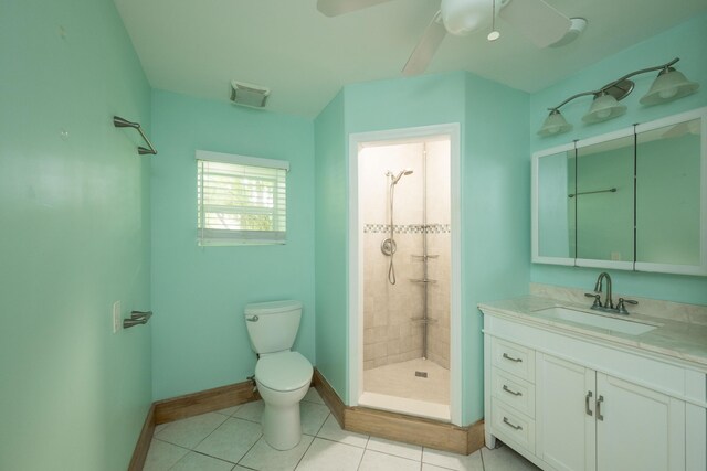 bathroom featuring ceiling fan, a tile shower, vanity, tile patterned floors, and toilet