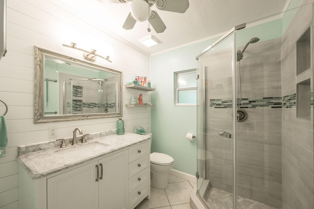 bathroom with crown molding, a shower with door, vanity, tile patterned floors, and toilet