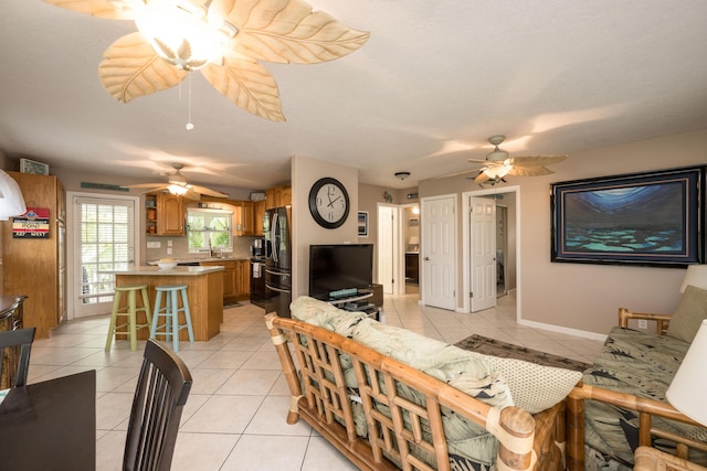 tiled living room featuring sink and ceiling fan