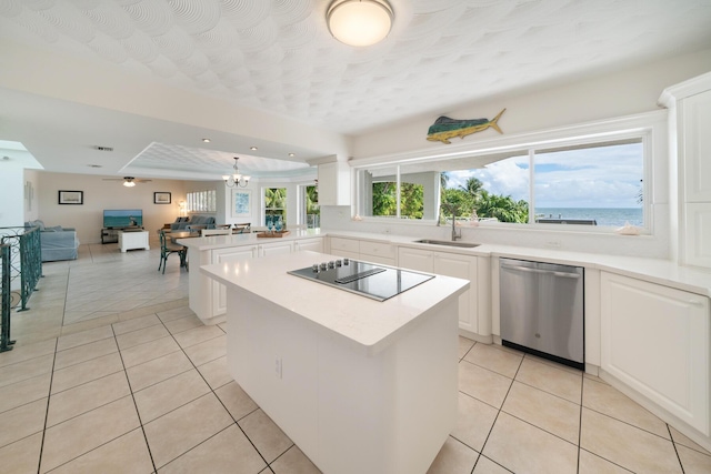 kitchen featuring sink, a water view, black electric cooktop, stainless steel dishwasher, and a kitchen island