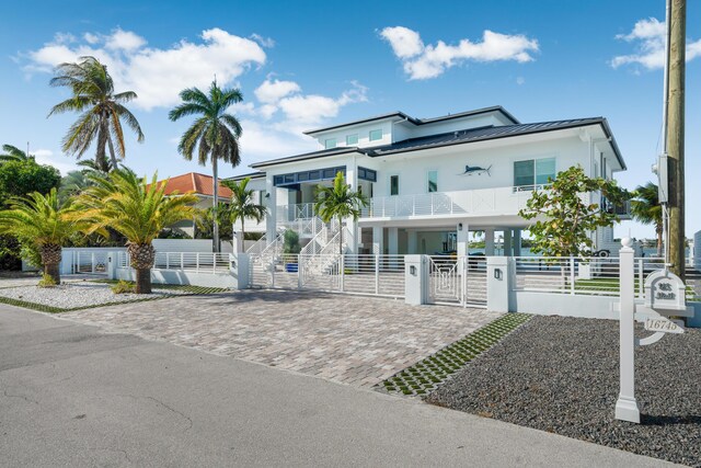 16745 Tamarind Rd, Sugarloaf, FL 33042 - coastal home with a fenced front yard, a gate, a balcony, a standing seam roof, and metal roof