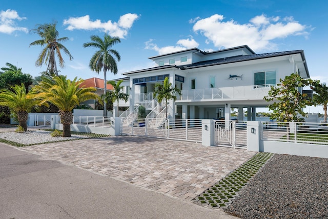 16745 Tamarind Rd, Sugarloaf, FL 33042 - raised beach house featuring a standing seam roof, a gate, a fenced front yard, stairway, and a carport