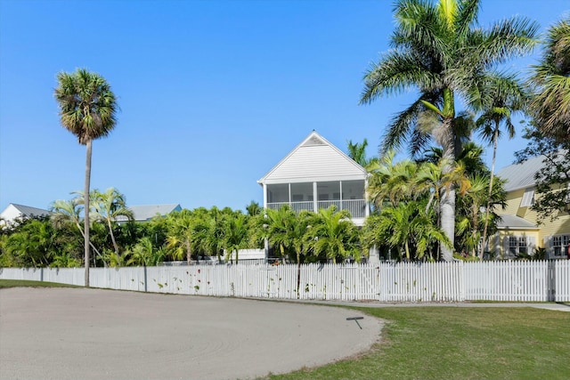 exterior space with a fenced front yard and a sunroom