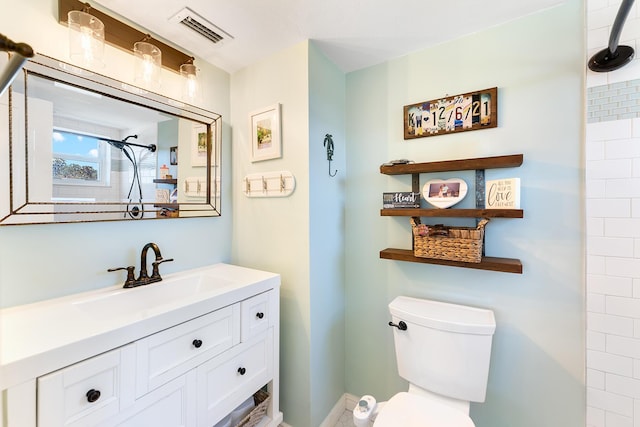 bathroom with vanity, toilet, and a tile shower