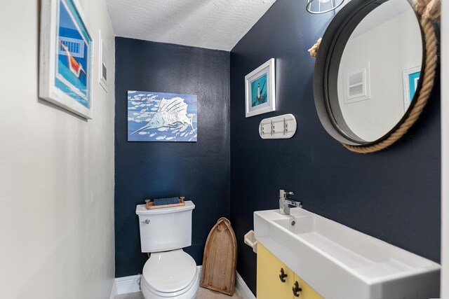 bathroom featuring sink, a textured ceiling, and toilet