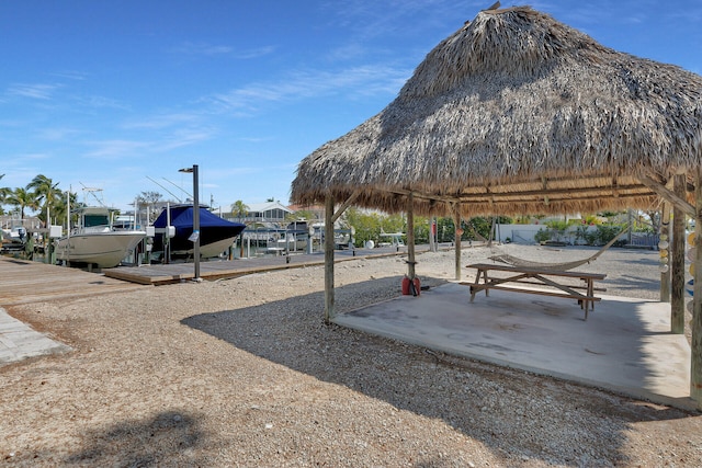 view of home's community featuring a gazebo, a dock, and a patio