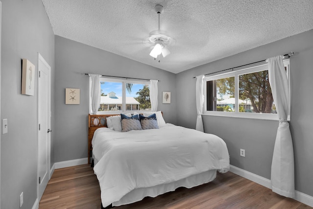 bedroom featuring vaulted ceiling, wood finished floors, and baseboards