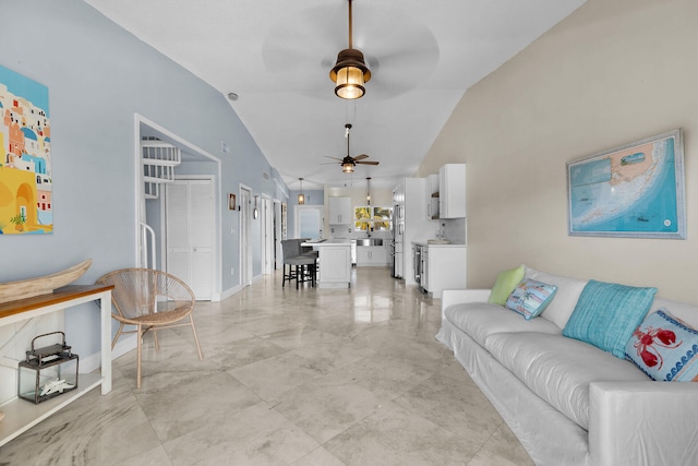 living room featuring baseboards, lofted ceiling, and a ceiling fan