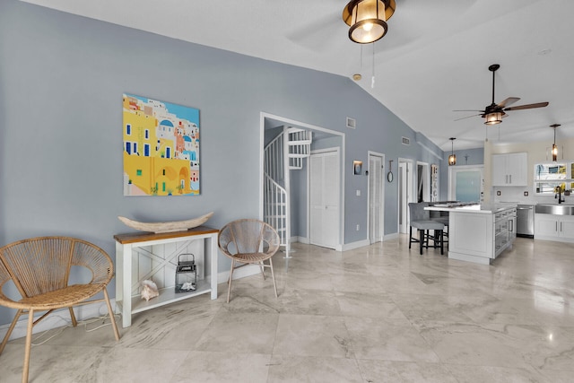 interior space featuring lofted ceiling, a ceiling fan, and baseboards