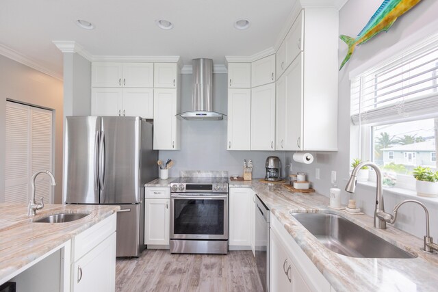 kitchen featuring stainless steel appliances, sink, wall chimney range hood, and white cabinets