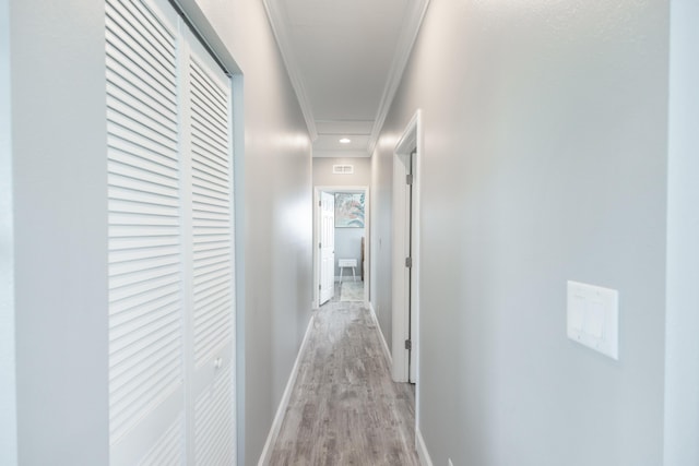 corridor with crown molding and light hardwood / wood-style floors