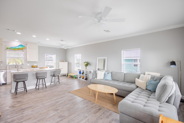 living room with sink, crown molding, light hardwood / wood-style flooring, and ceiling fan