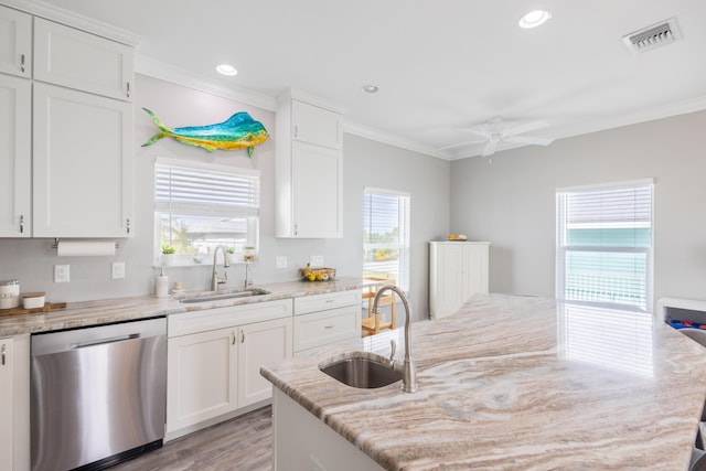 kitchen with light stone counters, stainless steel dishwasher, sink, and white cabinets