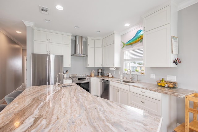 kitchen featuring stainless steel appliances, white cabinetry, wall chimney exhaust hood, and a kitchen breakfast bar