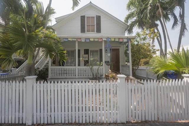 bungalow-style home featuring a porch and a fenced front yard