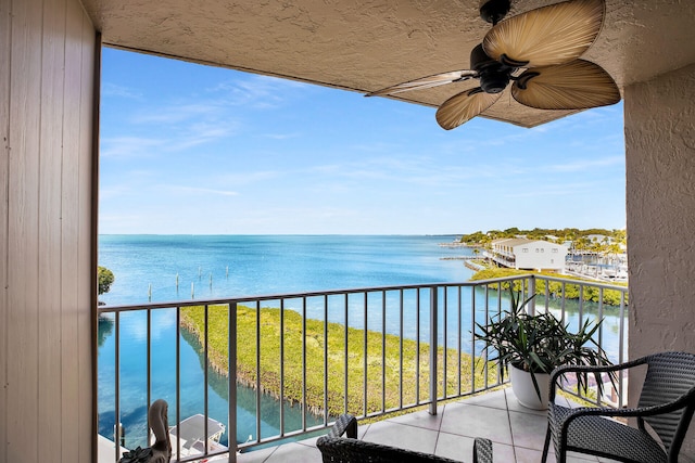 balcony featuring a water view and ceiling fan