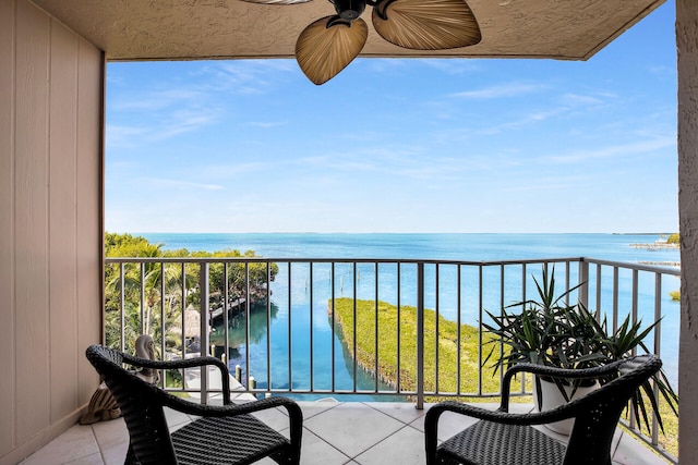 balcony featuring a water view and ceiling fan