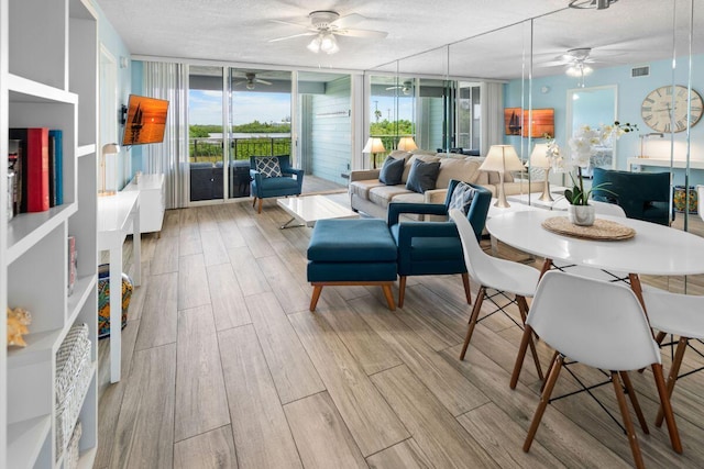 interior space with floor to ceiling windows, ceiling fan, a textured ceiling, and light hardwood / wood-style floors