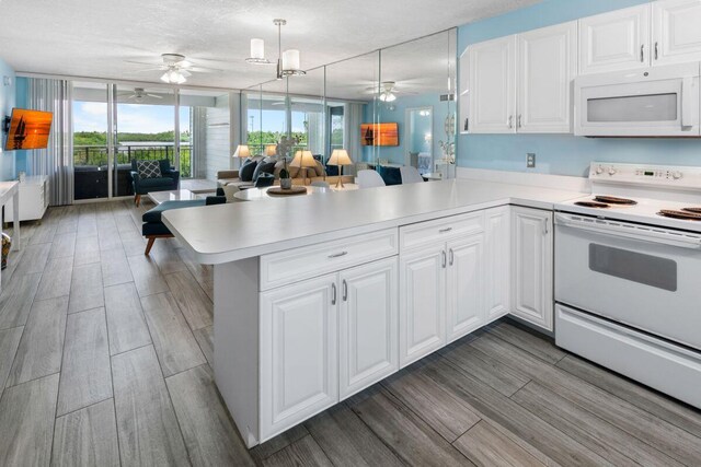 kitchen featuring white appliances, ceiling fan, white cabinetry, hanging light fixtures, and kitchen peninsula