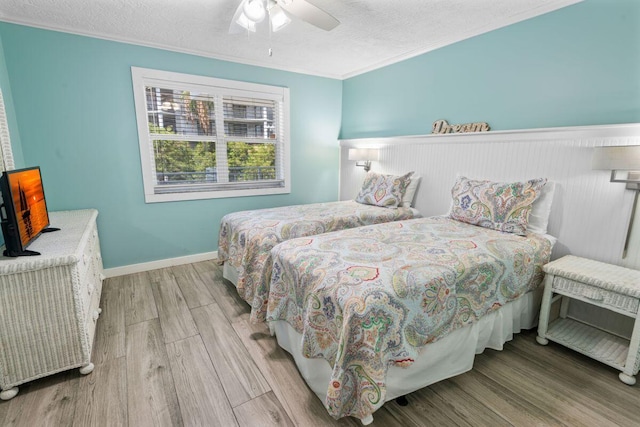 bedroom featuring ornamental molding, ceiling fan, a textured ceiling, and light hardwood / wood-style floors