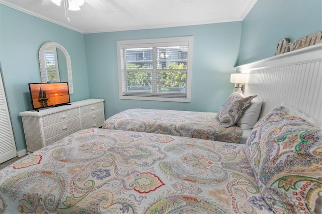 bedroom featuring ceiling fan, ornamental molding, and multiple windows