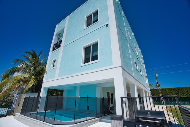 back of house featuring a fenced in pool