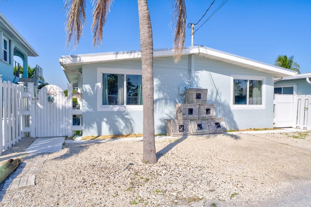 97 Coral Ln, Key Colony, FL 33051 - view of home's exterior with a gate and stucco siding