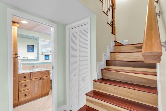 stairway featuring wood-type flooring and sink