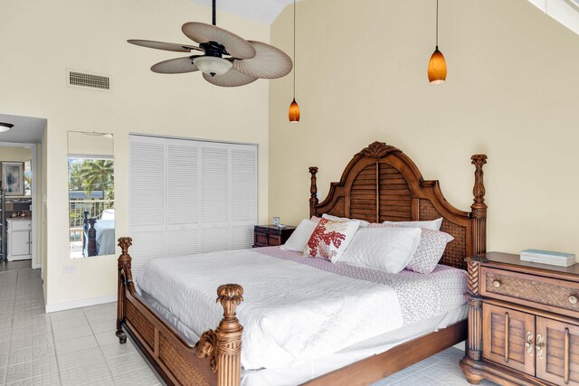 tiled bedroom featuring a closet, ceiling fan, and a high ceiling