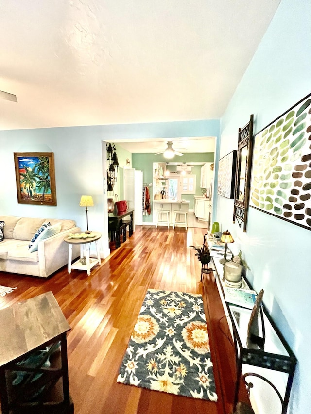 living area featuring ceiling fan and wood finished floors