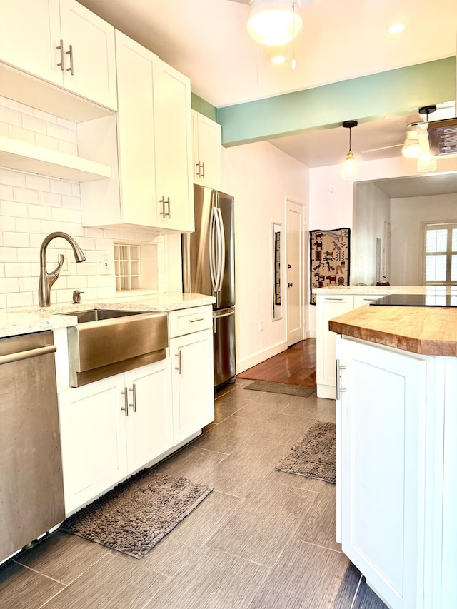 804 S St Unit 1, Key West, FL 33040 - kitchen with appliances with stainless steel finishes, a sink, butcher block countertops, decorative backsplash, and open shelves