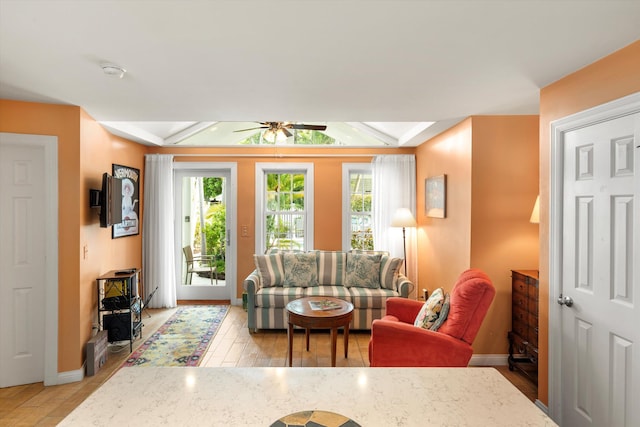 living room featuring ceiling fan, light wood-type flooring, and a wealth of natural light