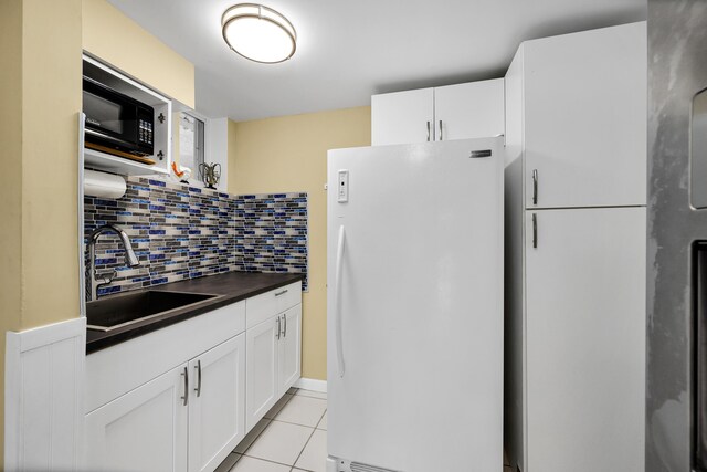 kitchen featuring sink, white cabinets, backsplash, white fridge, and light tile patterned floors