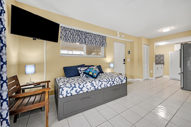 tiled bedroom featuring stainless steel refrigerator, a closet, and white fridge