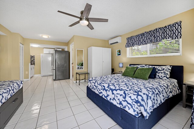 tiled bedroom featuring stainless steel refrigerator, ceiling fan, a textured ceiling, and an AC wall unit