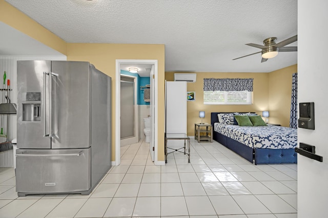 bedroom with light tile patterned flooring, high quality fridge, a wall unit AC, and a textured ceiling