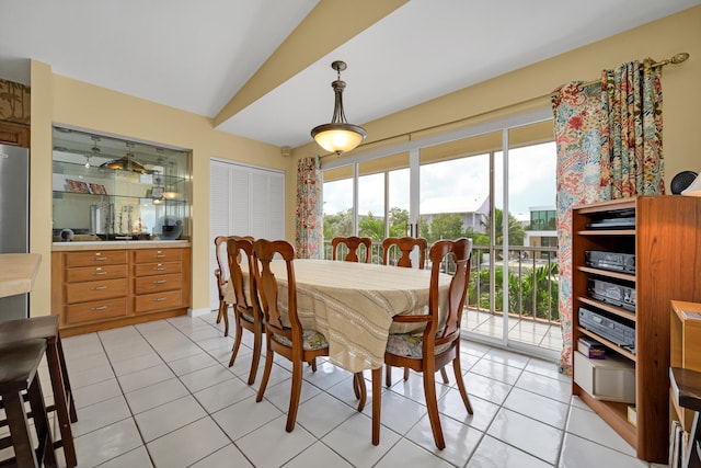 dining space featuring lofted ceiling and light tile patterned floors