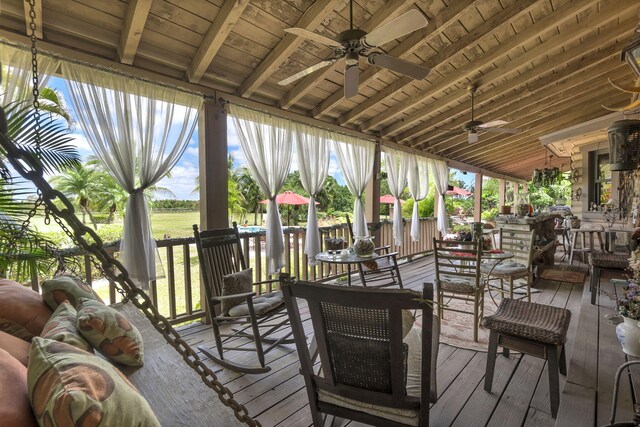 wooden terrace with ceiling fan and an outdoor hangout area