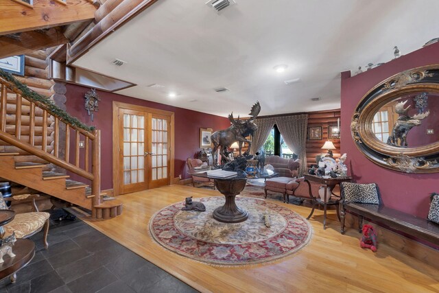 interior space with wood-type flooring, log walls, and french doors