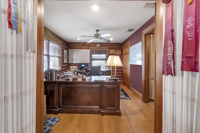 office area featuring log walls, light hardwood / wood-style floors, and ceiling fan