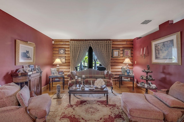 living room with light hardwood / wood-style flooring and rustic walls