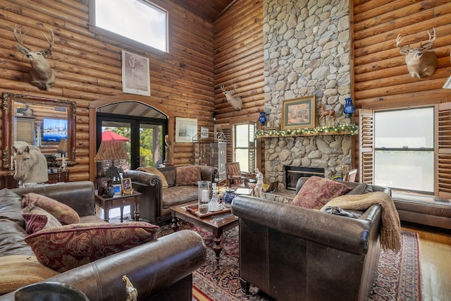 living room featuring hardwood / wood-style flooring, a fireplace, rustic walls, and a high ceiling