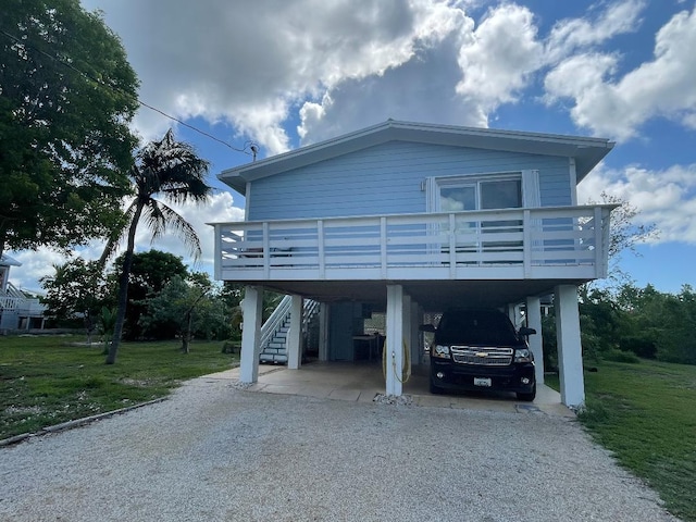 view of front of home with a carport, a deck, and a front yard