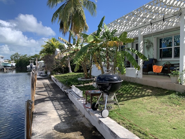 view of home's community featuring a water view, a yard, and a boat dock