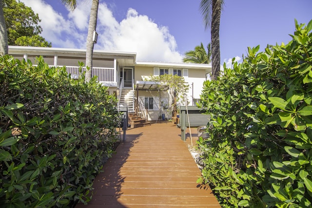 back of property featuring a hot tub and a pergola